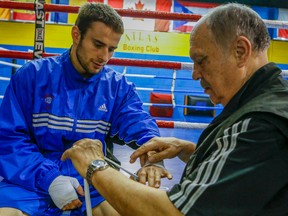 Coach Adrian Teodorescu (right) tapes up the hands of lightweight boxer Arthur Biyarslanov at Atlas Gym. The boxer is outraged Teodorescu won’t be in his corner when the Pan Am Games begin. Boxing Canada opted against naming Teodorescu to its coaching staff despite the fact he has three fighters at the Games. (DAVE THOMAS/Toronto Sun)
