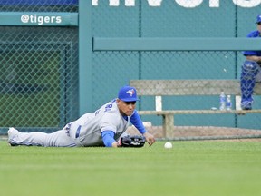 Jays left-fielder Ezequiel Carrera has the ball pop out of his glove in the fourth inning last night in Detroit. Carrera would commit two throwing errors in the inning as Drew Hutchison and the Jays, despite a six-run comeback, lost 8-6 to the Tigers. (AP)
