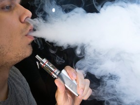 Mike Livingston, an employee at 180 Smoke, blows out vapour from an e-juice cigarette on Friday June 19, 2015. Craig Robertson/Toronto Sun