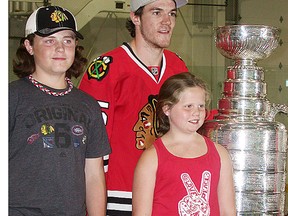 Belleville's Andrew Shaw of the Chicago Blackhawks shares a Stanley Cup moment with local fans Zach Maracle, 12, and Hayley Maracle, nine, Saturday at the Sports Centre. (Paul Svoboda/The Intelligencer)