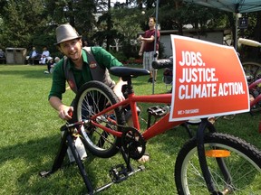 Brad Curtis with People Powered Parties works on a bike that helped power live music Saturday during a gathering on the Alberta legislature grounds calling for action on climate change and economic diversification. Kevin Maimann photo