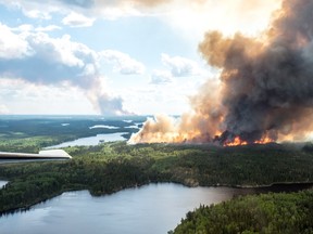 Smoke and flames rise from a forest in the LaRonge, Sask., area in this July 1, 2015 handout photo from the Saskatchewan Ministry of Environment. (THE CANADIAN PRESS/Saskatchewan Ministry of Environment Wildfire Branch)