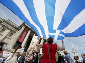 A woman holds the flag of Greece at the 'Greek solidarity festival' in Trafalgar Square, London, Britain, July 4, 2015. The event was held in support of the people of Greece and the cancellation of debt, ahead of their referendum on Sunday. (REUTERS/Peter Nicholls)