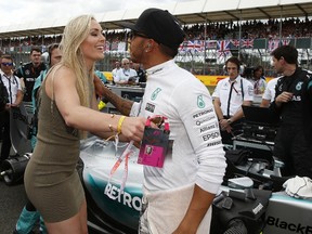 British driver Lewis Hamilton receives a kiss from skier Lindsey Vonn before the British Grand Prix at the Silverstone Race Circuit yesterday.