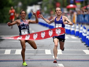 Winner of the men's AJC Peachtree Road Race Scott Overall, right, breaks away from Ben Payne who finished second Saturday, July 4, 2015, in Atlanta. (Hyosub Shin/Atlanta Journal-Constitution via AP)