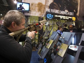 Mark Heitz, of Tactical Firearms in Kingston, New Hampshire, looks over a civilian version of the Colt M4 carbine during the annual SHOT (Shooting, Hunting, Outdoor Trade) Show in Las Vegas, in this file photo taken January 15, 2013. (REUTERS/Las Vegas Sun/Steve Marcus/Files)