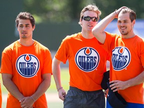 Oilers prospects Tyler Vesel (left), Connor McDavid (centre) and Greg Chase are seen during a charity softball game between members of the Edmonton Police Service and the Edmonton Oilers Prospects at Telus Field in Edmonton, Alta., on Sunday July 5, 2015. The event benefits Constable Woodall Family Fund. Ian Kucerak/Edmonton Sun/Postmedia Network