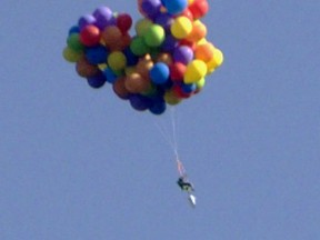 The man who strapped himself to a lawn chair attached with balloons for an attempted drop into Stampede Park on Sunday, July 5, has been identified as Daniel Boria. Despite a set of charges police have laid, the man is more elated than deflated. (Photo courtesy Tom Warne)