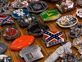 Belt buckles on display, and for sale, at a booth in the BMO Centre during the Calgary Stampede in Calgary, Alta on Sunday Jul 5, 2015. Given the controversy over the flag, Stampede officials say that they are taking action on vendors who choose to sell them.  Gavin John/Calgary Sun