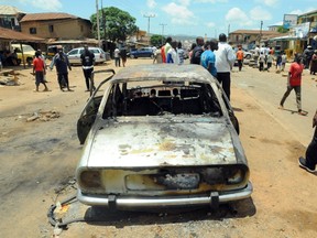 The wreckage of car is pictured on July 6, 2015 in the central Nigerian city of Jos, Plateau State, the day after a twin bomb blasts that killed at least 44 people, after a wave of mass casualty attacks blamed on Boko Haram militants. The blasts happened within minutes of each other at a shopping complex and near a mosque in the religiously divided capital of Plateau state, which the rebels have targeted before. The bombings took the death toll from raids, explosions and suicide attacks to 267 this month alone and to 524 since Muhammadu Buhari became president on May 29, according to an AFP count. AFP PHOTO