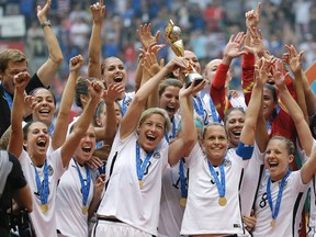 The United States Women's National Team celebrates with the trophy after they beat Japan 5-2 in the FIFA Women's World Cup soccer championship in Vancouver, British Columbia, Canada, Sunday, July 5, 2015. (AP Photo/Elaine Thompson)