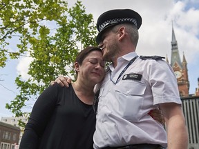 Gill Hicks, left, a survivor of the 7/7 London terror attacks, embraces police constable Andrew Maxwell outside Kings Cross Station in London on July 6, 2015, during an event to launch a walk by faith leaders promoting religious unity ahead of the anniversary of the attacks. PC Maxwell was one of the police officers who saved Hicks' life following a detonated explosion aboard the Piccadilly line train in which she was travelling between Kings Cross and Russell Square Station on July 7, 2005. (AFP PHOTO/NIKLAS HALLE'N)