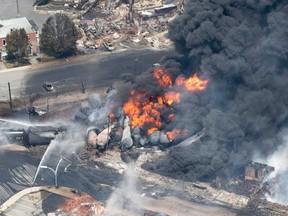 Smoke rises from railway cars that were carrying crude oil after derailing in downtown Lac-Megantic, Que., on July 6, 2013. Two years after a tragic train derailment decimated the Quebec town, a church bell rang 47 times in memory of the victims. THE CANADIAN PRESS/Paul Chiasson