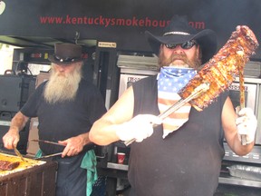 Tex Robert Jr., also known as Grandpa Kentucky, right, holds up a rack of ribs prepared by the Kentucky Smokehouse professional ribbing team at Chatham's Ribfest on July 4.