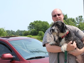 Frank Rockett, executive director of the Quinte Humane Society stands outside of the Humane Society with Freddie, a shelter animal. Rockett, along with officers,  veterinarians and other animal caretakers are asking pet owners to not leave their animals in vehicles in the heat.