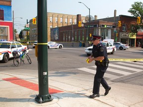 Staff Sgt. Jeff Dunham tapes off the accident scene at Adelaide and Dundas where a skateboarder was run over by a south bound transport truck. (MIKE HENSEN, The London Free Press)