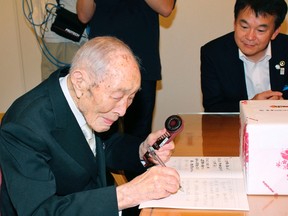 Sakari Momoi (L), a resident of Saitama prefecture, writes a message to communicate with Saitama Mayor Hayato Shimizu (R) in Tokyo, in this Kyodo file photo taken September 2013.
REUTERS/Kyodo/Files