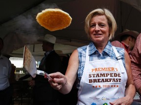 Alberta Premier Rachel Notley flips pancakes at the annual Premier's Stampede breakfast in Calgary, Alta., on Monday, July 6, 2015. (Jeff McIntosh/The Canadian Press)