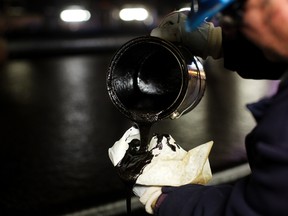 An oil sands worker checks the oil during the first step of separation at the Suncor processing plant at their tar sands operations near Fort McMurray, Alberta, in this September 17, 2014, file photo. (REUTERS/Todd Korol/Files)