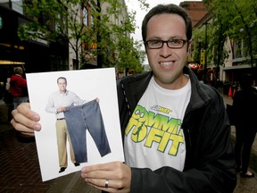 Jared Fogle, the Subway restaurant poster boy who lost 245 pounds on a Subway diet, mugs with a photo of his former self in Calgary, Alta., in this June 15, 2011 file photo. (LYLE ASPINALL/CALGARY SUN/Postmedia Network)