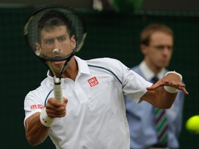 Novak Djokovic of Serbia returns a ball to Kevin Anderson of South Africa during their singles match against at the All England Lawn Tennis Championships in Wimbledon, London, Tuesday July 7, 2015. (AP Photo/Alastair Grant)