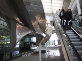 Travellers on an escalator pass by the 78-metre-long sculpture "Slipstream" at Terminal 2 of London's Heathrow Airport on May 18, 2015.  THE CANADIAN PRESS/Mike Fuhrmann