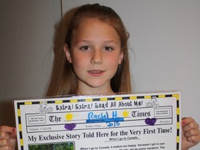 Supplied photo
Rachel Holderman, 8, with the newspaper she created as a Grade 3 project.