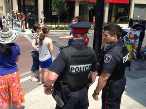 Police stand watch at an anti-abortion rally on Princess Street in Kingston, Ont. in Kingston, Ont. on Tuesday, July 7, 2015. 
Elliot Ferguson/The Whig-Standard