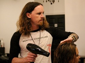 Chris Norton blow-dries a client's hair in his family's salon, Norton Hairstyling. He and his wife will be heading to Toronto this week to help style the hair of 400 Cirque du Soleil performers. (Chris O'Gorman/Sarnia Observer/Postmedia Network)
