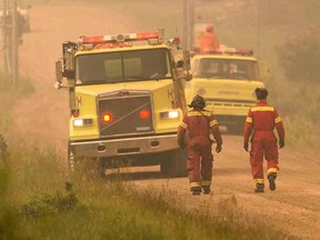 Fire trucks arrive to tackle a blaze near La Ronge, Saskatchewan July 4, 2015 in a picture provided by Saskatchewan Ministry of Environment contract pilot Corey Hardcastle. The Canadian military has been called in to help fight wildfires in the Western province of Saskatchewan, where 112 active fires have forced the evacuation of more than 13,000 people and threatened several remote towns on Monday. Picture taken July 4, 2015.  REUTERS/Corey Hardcastle/Handout via Reuters