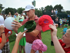PGA golfer Jordan Spieth signs autographs at the John Deere Classic as he arrives to the practice range on July 7, 2015, in Silvis, Ill. (Paul Colletti/The Dispatch via AP)