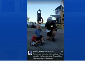 Declan Tramley, 3, is pictured sitting on his bike, while Cst. Shawn Currie issues the toddler his first 'ticket'. (CTV News/YouTube screengrab)