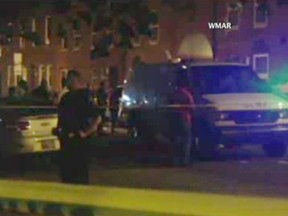 In this image taken from video, police investigate the scene of a shooting, Tuesday, July 7, 2015, in Baltimore. Baltimore police say four people have been shot, three fatally, near the University of Maryland campus. WMAR via AP