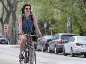 A cyclist rides her bike down Assiniboine Avenue earlier this year. (Brian Donogh/Winnipeg Sun file photo)