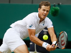 Vasek Pospisil of Canada returns a shot to  Andy Murray of Britain during the men's quarterfinal singles match at the All England Lawn Tennis Championships in Wimbledon, London, Wednesday July 8, 2015. (AP Photo/Kirsty Wigglesworth)