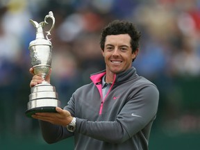 Rory McIlroy holds up the Claret Jug after winning the British Open at the Royal Liverpool golf club, Hoylake, England last year. McIlroy won't be back to defend his title in the British Open after announcing Wednesday, July 8, 2015 that a ruptured ligament in his left ankle will keep him from St. Andrews. (Scott Heppell/AP Photo/Files)