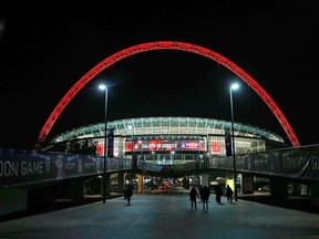Fans arrive for an NFL football game between the Dallas Cowboys and the Jacksonville Jaguars at Wembley Stadium in London, November 9, 2014. The arch is covered in red lights in honor of Remembrance Sunday. REUTERS/Suzanne Plunkett (BRITAIN - Tags: SPORT FOOTBALL)