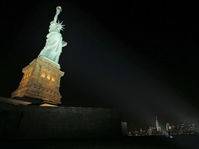 New light-emitting diodes or LEDs illuminate the Statue of Liberty on Liberty Island after the new system was turned on in New York, Tuesday, July 7, 2015. (AP Photo/Kathy Willens)