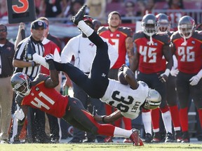 Saints' Travaris Cadet gets tripped up along the sideline by Buccaneers cornerback C.J. Wilson during NFL action in Tampa, Fla., on Dec. 28, 2014. (Joe Robbins/Getty Images/AFP)