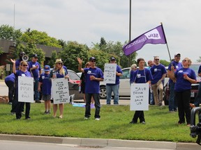 Unionized Sarnia-Lambton and Chatham-Kent paramedics protest outside the County of Lambton administration building on Wednesday in Wyoming. They're calling for better support for colleagues diagnosed with post-traumatic stress disorder. (Barbara Simpson/Sarnia Observer/Postmedia Network)