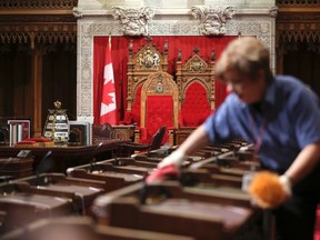 A worker cleans desks in the Senate chamber on Parliament Hill in Ottawa. REUTERS/Chris Wattie