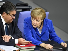 German Chancellor Angela Merkel looking at the mobile phone of Vice Chancellor, Economy and Energy Minister Sigmar Gabriel during a session of the German Bundestag (lower house of parliament) in Berlin. New documents released by WikiLeaks show that the United States did not just tap German Chancellor Angela Merkel's phone but also eavesdropped on several ministers. (AFP/TOBIAS SCHWARZ)