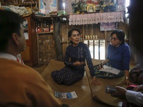 Myanmar pro-democracy leader Aung San Suu Kyi explains a villager in Warheinkha village during her door-to-door visits for voter education campaign in her constituency  town Khawhmu, outside Yangon July 4, 2015. Suu Kyi's National League for Democracy (NLD) is expected to do well in a parliamentary election, which will be the first free and fair vote in Myanmar in 25 years. The NLD, which has a history of boycotting what it saw as flawed political processes inspired by the former military dictatorship, has yet to confirm whether or not it will run in November's general election. REUTERS/Soe Zeya Tun