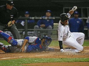 Adam LaRoche of the Chicago White Sox scores a run in the sixth inning as Dioner Navarro of the Toronto Blue Jays attempts the tag at U.S. Cellular Field on July 8, 2015. (Jonathan Daniel/Getty Images/AFP)