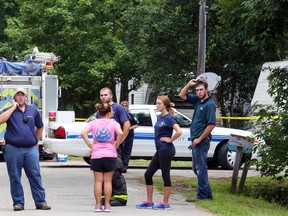 Emergency personnel from Berkeley County stand outside a campground surrounded by police tape near Moncks Corner, S.C., Tuesday, July 7, 2015, after an F-16 fighter jet smashed into a small plane over South Carolina. (Brad Nettles/The Post and Courier via AP)
