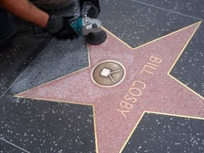 A worker cleans graffiti on actor Bill Cosby's star on the Hollywood Walk of Fame in Los Angeles December 5, 2014.  REUTERS/Phil McCarten