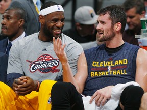 In this Nov. 7, 2014, file photo, Cleveland Cavaliers forwards LeBron James, left, and Kevin Love joke with each other on the bench in the fourth quarter of the Cavaliers' 110-101 victory over the Denver Nuggets in an NBA basketball game in Denver. Forward Kevin Love says he and superstar LeBron James had a "very honest" talk before he decided to re-sign as a free agent with the Cavaliers. (AP Photo/David Zalubowski, File)