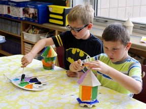 Taylor Button, 7, left, and Cameron Jackson, 8, decorate birdhouses Thursday during the first week of a new summer camp being held at St. Matthew Catholic School. After launching its camp program in Chatham last year, the St. Clair Catholic District School Board expanded the initiative to Sarnia to help students keep up with their learning over the summer months. (CHRIS O'GORMAN/THE OBSERVER)