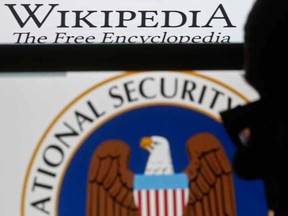 A man is silhouetted near logos of the U.S. National Security Agency (NSA) and Wikipedia in this photo illustration taken in Sarajevo March 11, 2015. NSA was sued on March 10, 2015, by Wikimedia and other groups challenging one of its mass surveillance programs that they said violates Americans' privacy and makes individuals worldwide less likely to share sensitive information. REUTERS/Dado Ruvic