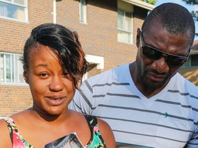 Alicia Jasquith, mother of 14-year-old Lecent Ross, with Lecent's uncle, Troy Ross, holds up photos of her daughter after her shooting death on Jamestown Cres. Thursday July 9, 2015. (Dave Thomas/Toronto Sun)